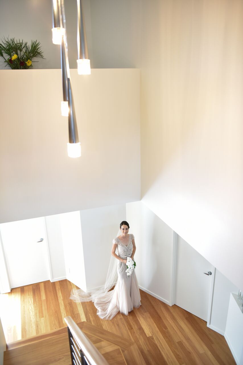 Downward looking photo of bride at bottom of staircase