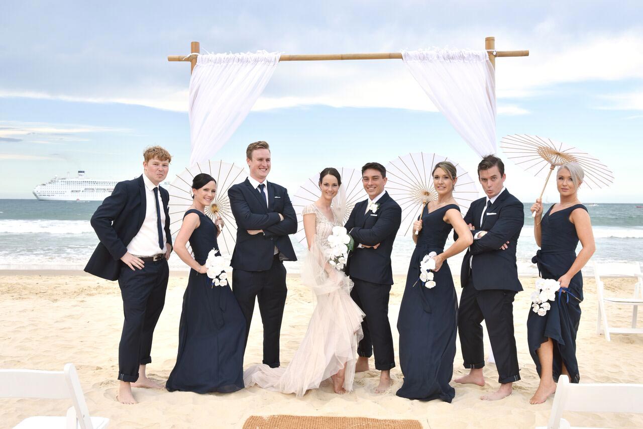 Bridal party and groomsmen posing against Mooloolaba beach