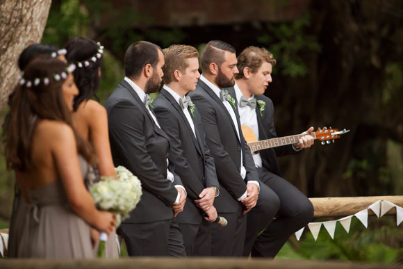 Grooms lined up with one playing the guitar