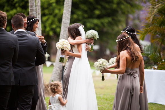 Bride and bridesmaid embracing at ceremony