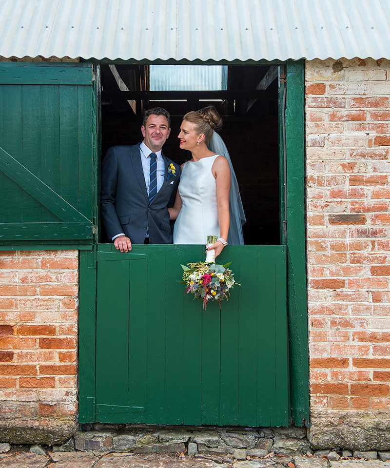 Bride and Groom captured in a horse stable.
