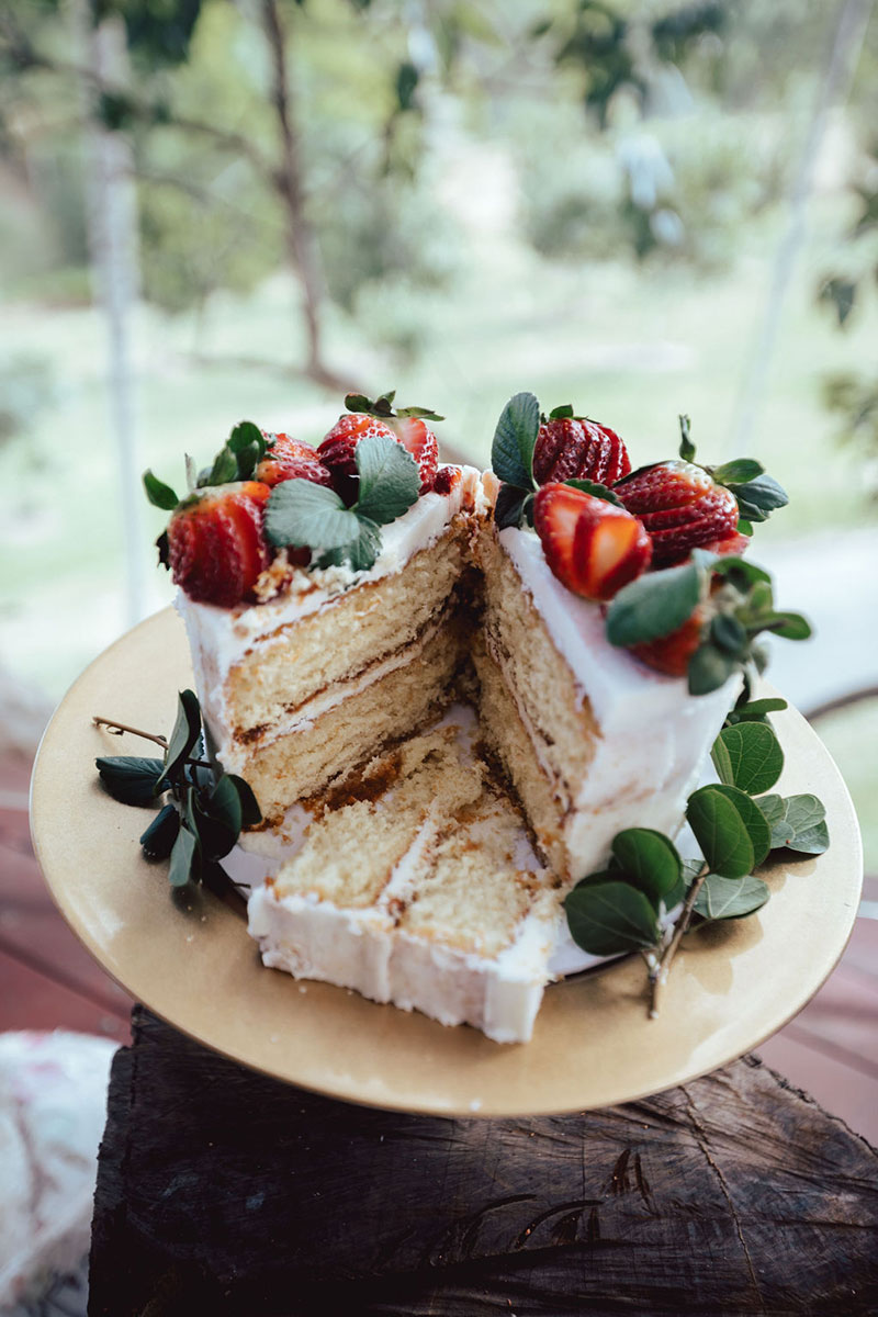 Photo by DK and Co. Photography of cake with white glaze and strawberries.