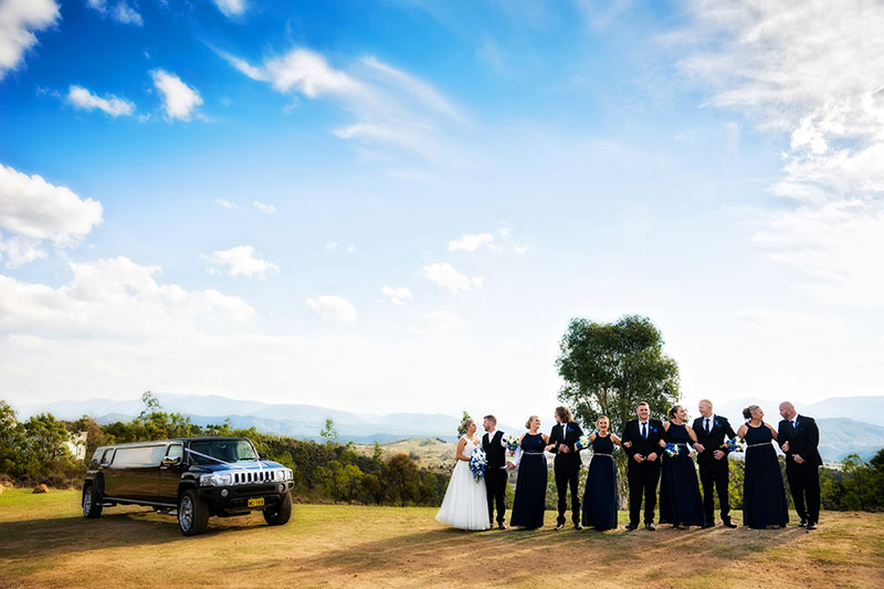 Atmospheric shot of wedding party and transport in country setting.