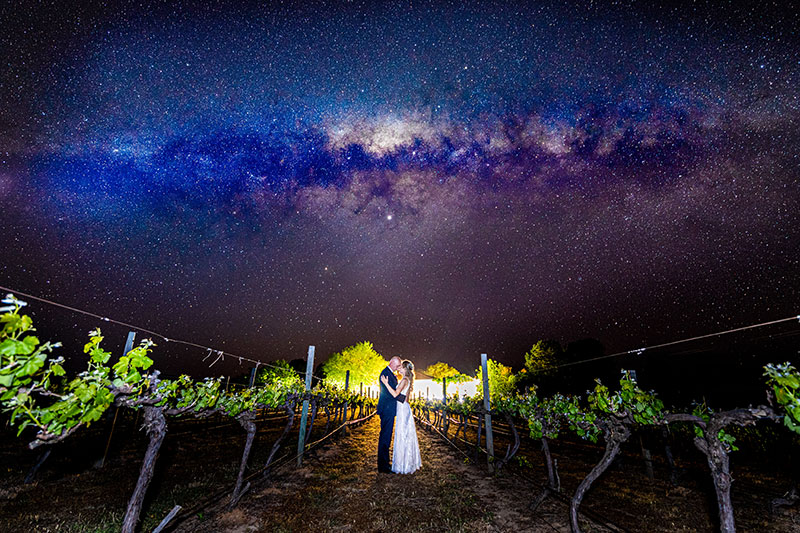 Bride and Groom hugging under a beautiful starry night sky.