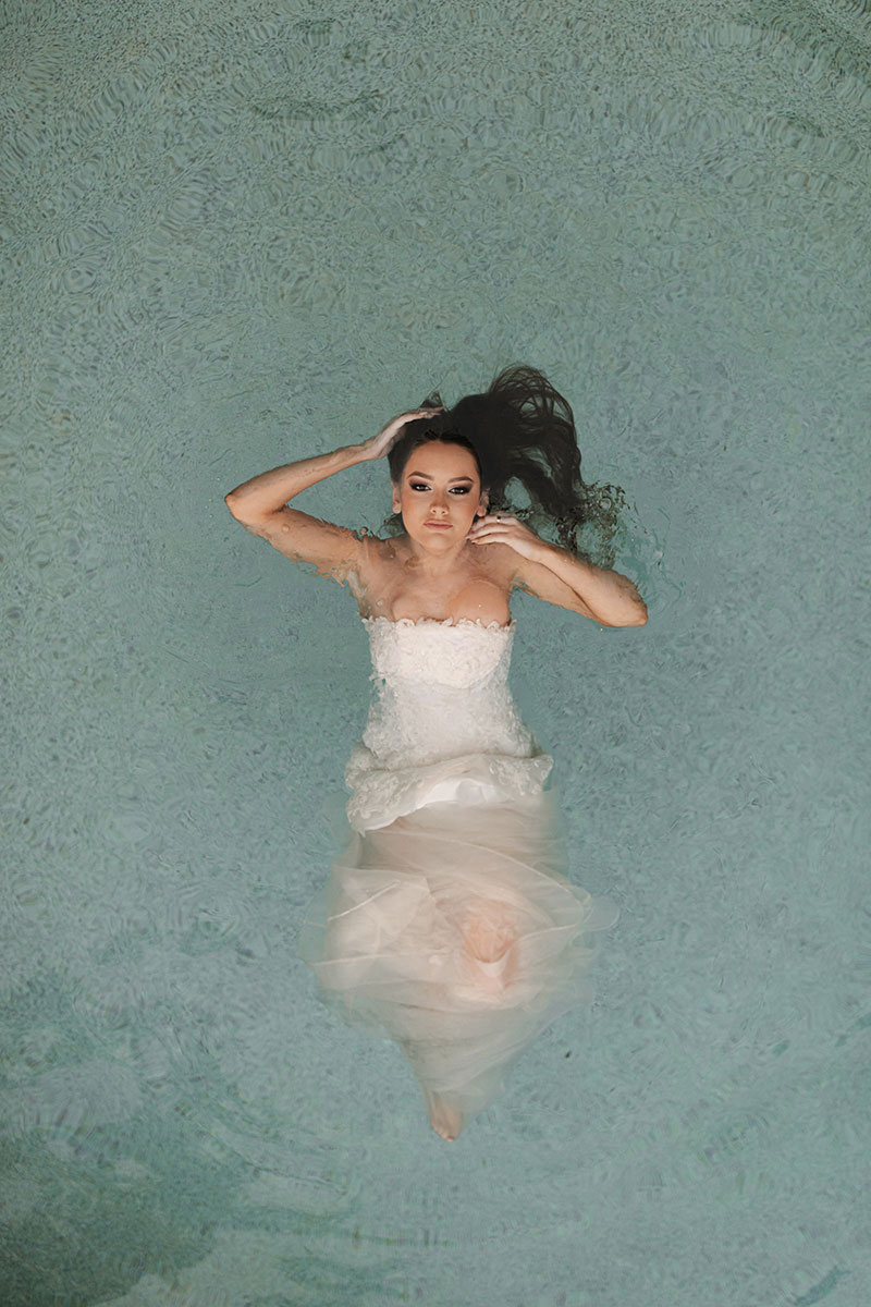 Photo by Tom Judson Photography of model wearing wedding gown in pool.