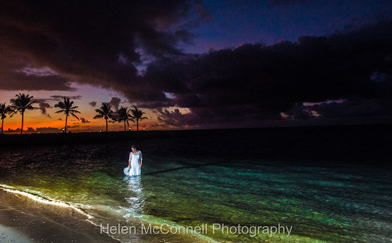 Colourful sunset overhead with bride in the sea.