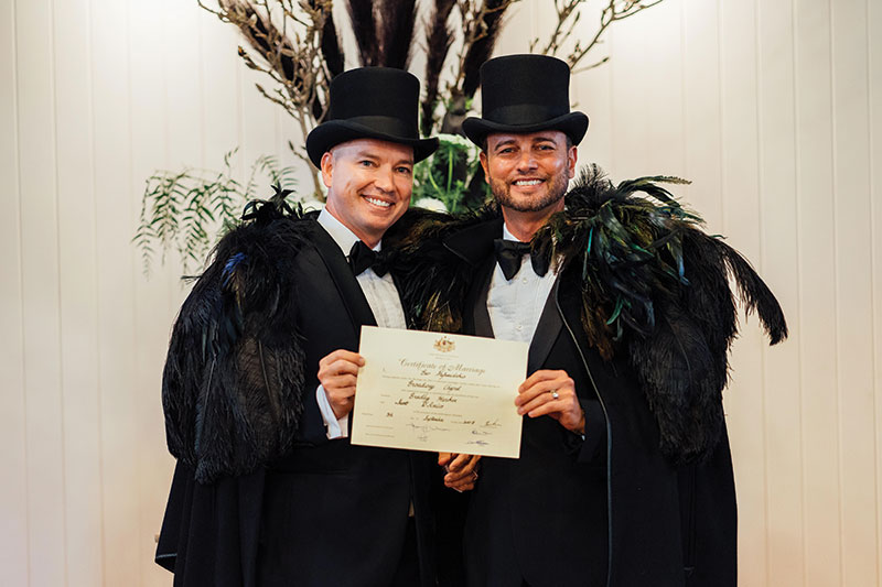 Brad and Scott happily pose with their marriage certificate at Broadway Chapel.