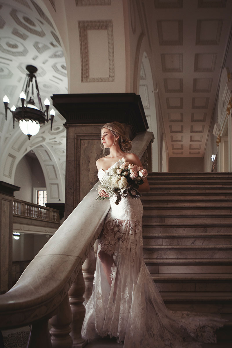 Bride wearing a Fiorenza wedding gown standing on stairs