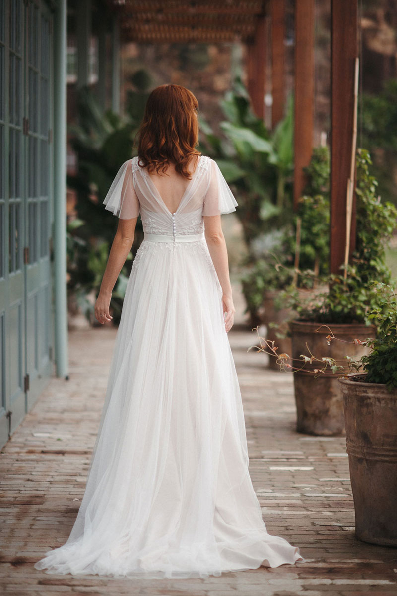Rear view of a red-haired bride wearing Dahlia from French by Wendy Makin.