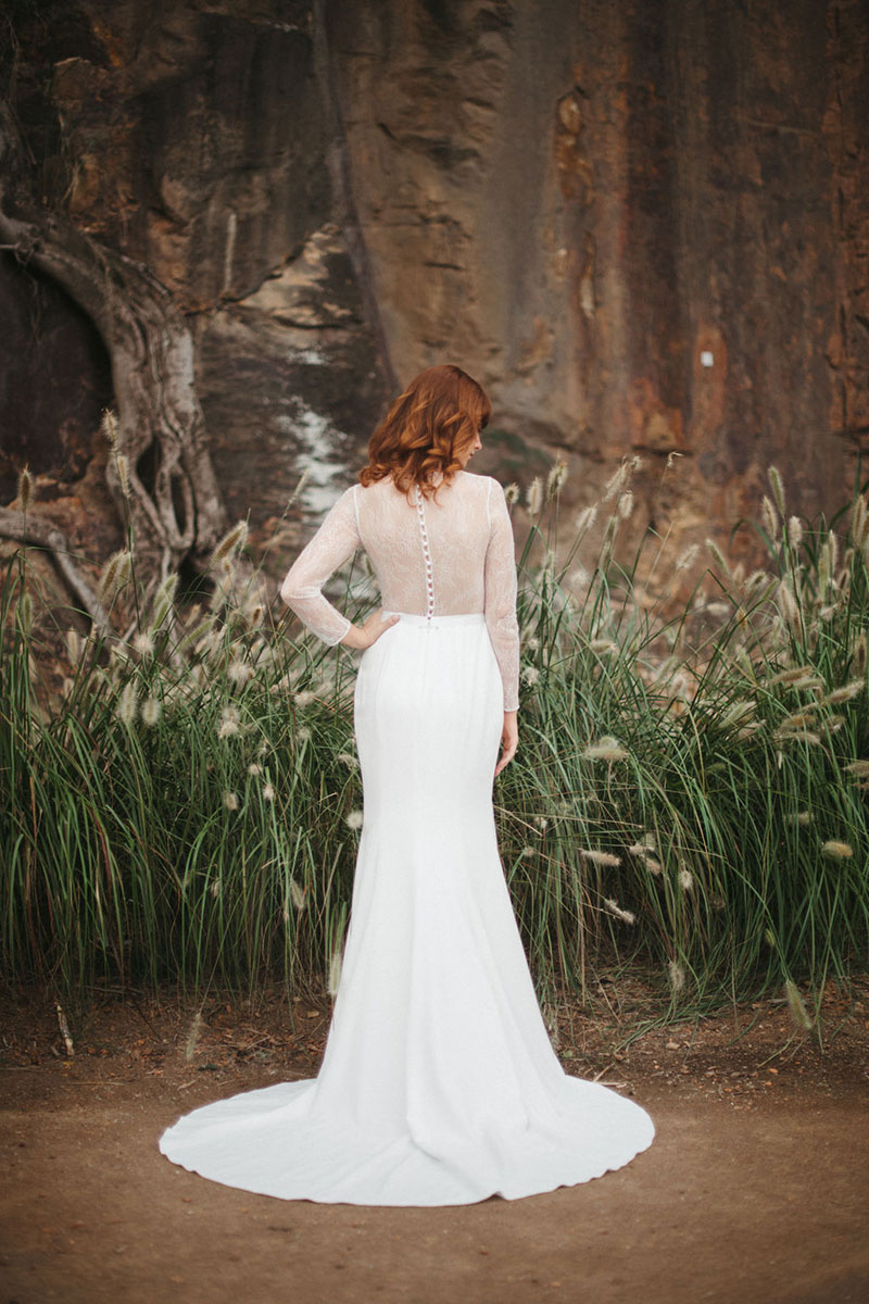 Back view of a long sleeved wedding gown with a circular train.
