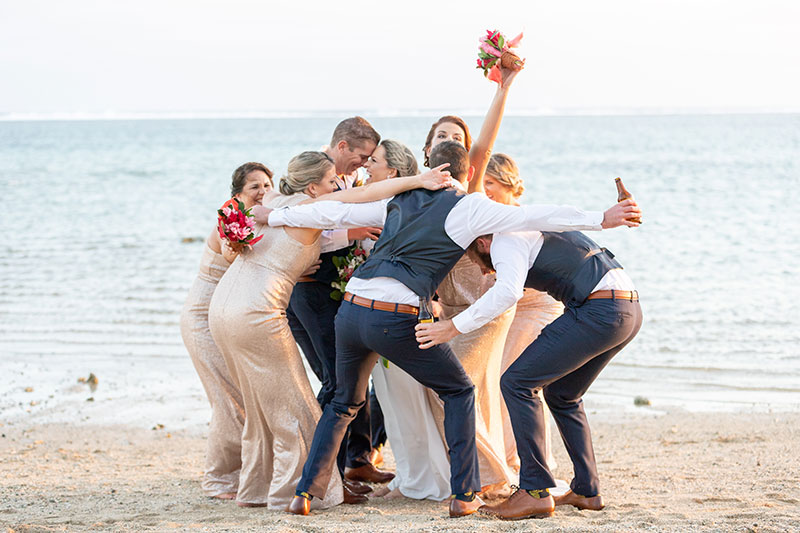 Wedding party grouped together on the beach.