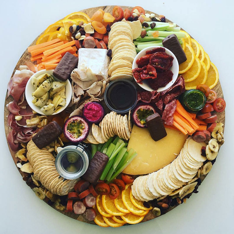 Round Grazing platter board with an assortment of food.