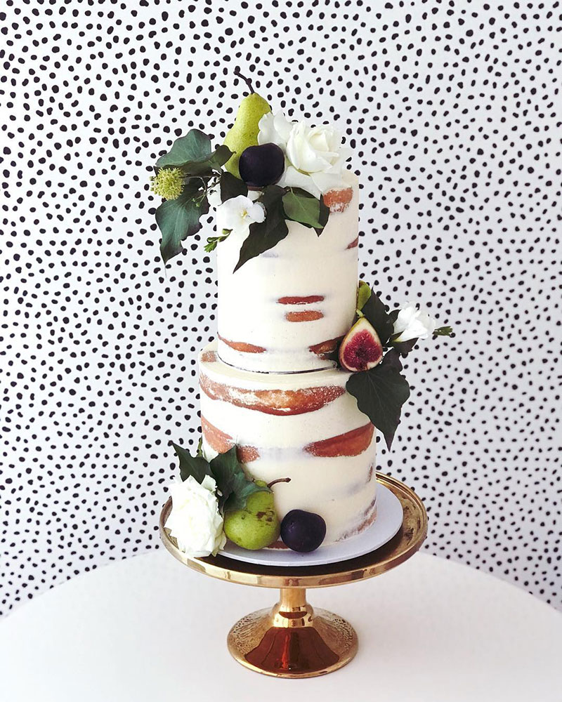 Rustic Wedding cake with crisp greens and seasonal fruits.