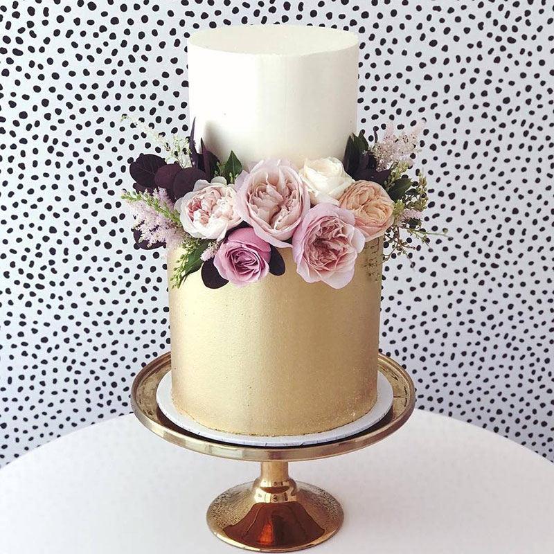 Metallic gold lustre wedding cake with flowers.