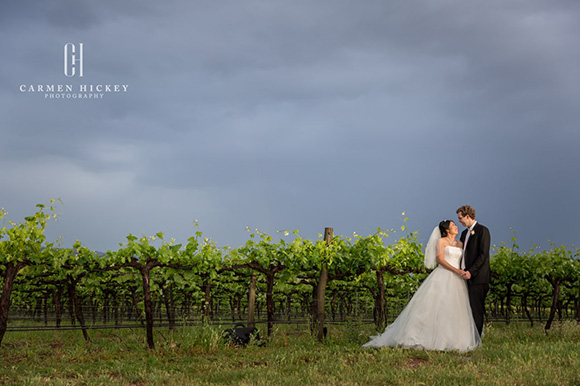 Margaret and Michael posing for photos under a moody sky after a downpour.