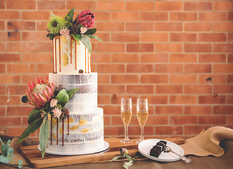 Rustic semi-naked wedding cake with native florals.