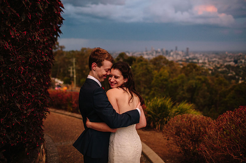 Bride and Groom hugging with Brisbane city views in the distance.