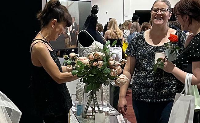 Wedding gown supplier talking with couple at booth